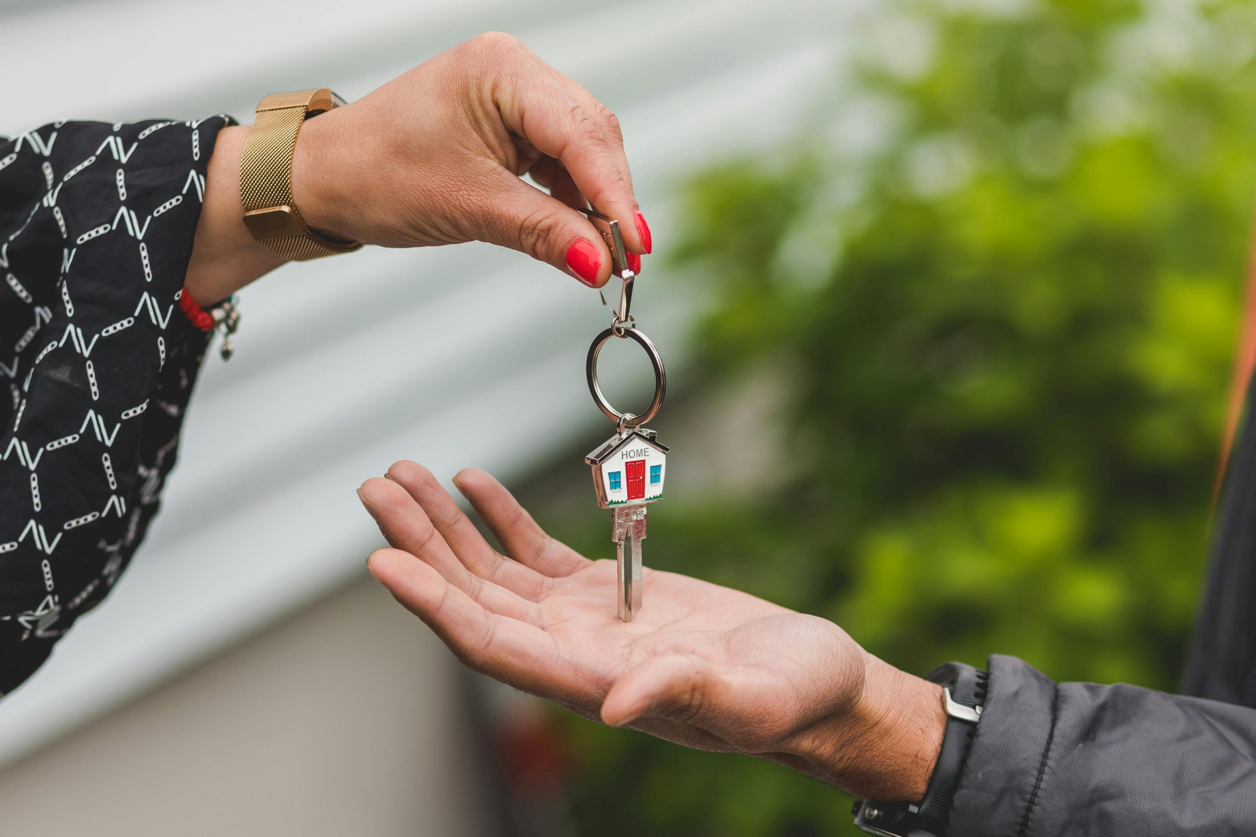 realtor handing a house-shaped key to a new homeowner