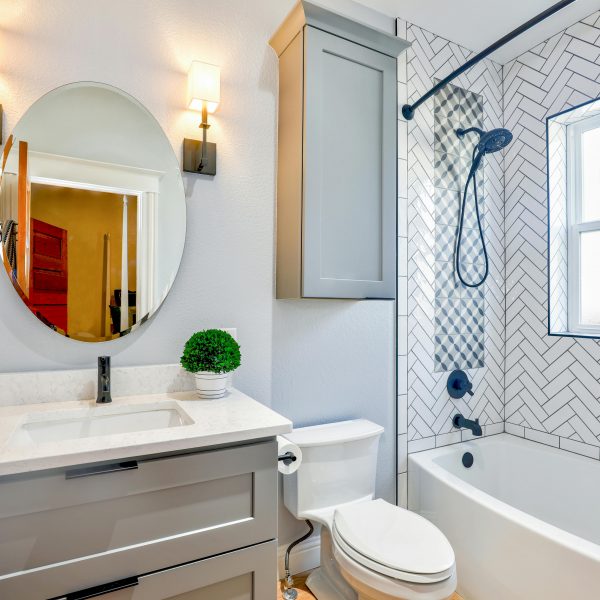 small bathroom with a mirrored vanity, a toilet, and a bathtub-shower combo